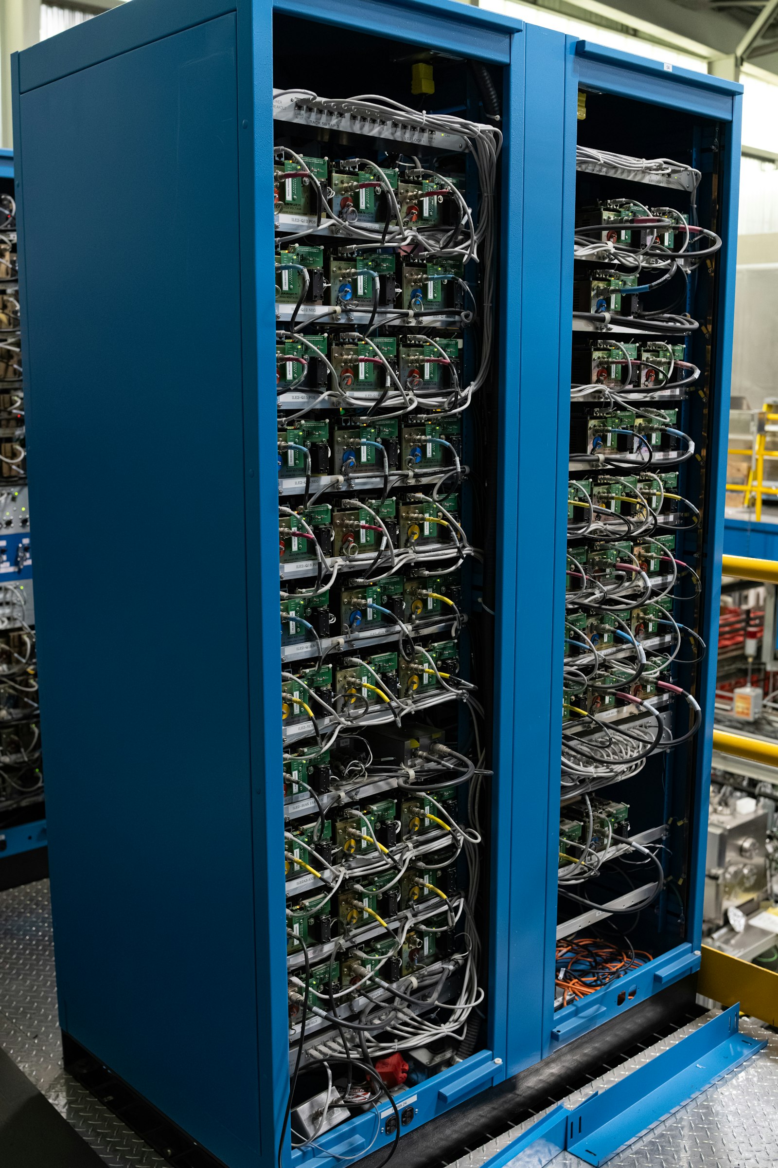 Open equipment cabinets, boards racked in rows and cabled by hand